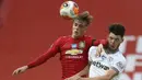 Pemain Manchester United, Brandon Williams, duel udara dengan pemain West Ham United, Declan Rice, pada laga Premier League di Stadion Old Trafford, Rabu (22/7/2020). Kedua tim bermain imbang 1-1. (Martin Rickett/Pool via AP)