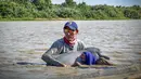 Gambar selebaran yang dirilis oleh Angkatan Laut Kolombia menunjukkan petugas menyelamatkan dua lumba-lumba merah muda (pink), spesies yang terancam punah, yang terperangkap di perairan dangkal di Juriepe, Departemen Vichada, Senin (20/2/2023). Para ahli mengevakuasi lumba-lumba itu keluar dari sungai dan dengan cepat memeriksa kondisi mereka dan melepaskannya ke perairan yang lebih dalam. (COLOMBIA'S NAVY / AFP)