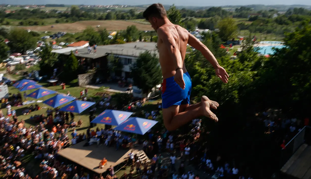 Seorang peserta bersiap melakukan terjun bebas dari jembatan Ura e Shejnt dalam kompetisi menyelam tradisional ke-68 di Gjakova, Kosovo, 22 Juli 2018. Kompetisi ini dilakukan dari ketinggian 22 meter. (AP/Visar Kryeziu)