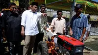 Menteri Desa, PDT dan Transmigrasi Marwan Jafar (kemeja putih) menyerahkan hand tracktor kepada perwakilan dua lelompok tani di Desa Huntu Barat, Bulango Selatan, Bone Bolango, Gorontalo, Minggu (10/1/2016). (Foto; Wahyu Wening/Humas Kemendes)