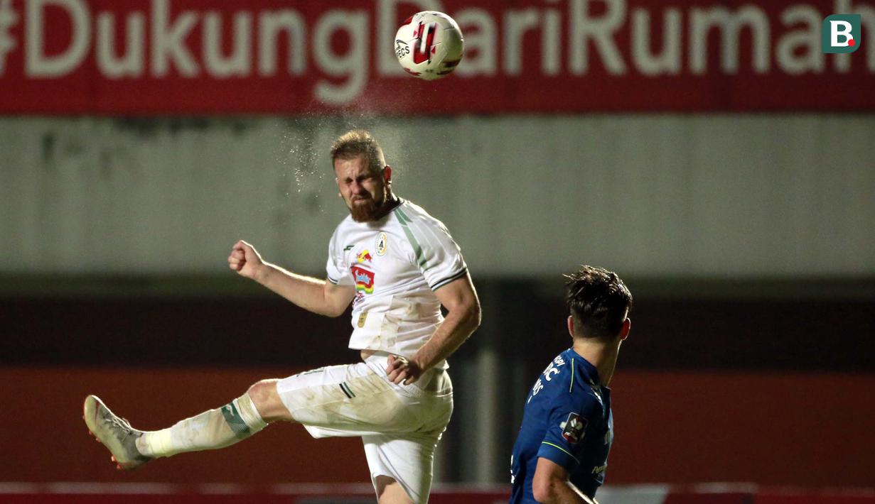 Pemain PS Sleman, Maslac Mario (kiri) menyundul bola dibayangi pemain Persib Bandung, Nick Kuipers dalam laga leg pertama semifinal Piala Menpora 2021 di Stadion Maguwoharjo, Sleman, Jumat (16/4/2021). (Bola.com/Ikhwan Yanuar)