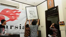 Pengurus Imparsial memasang lukisan Munir jelang memberi keterangan 12 tahun kasus Munir di Jakarta, Selasa (6/9). Imparsial memandang pengungkapan kasus Munir adalah agenda penting penuntasan kasus pelanggaran HAM. (Liputan6.com/Helmi Fithriansyah)