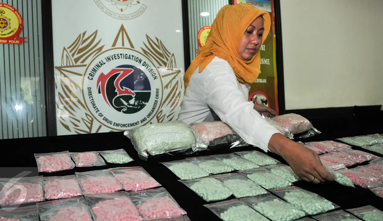 Petugas menata barang bukti narkoba saat rilis barang bukti di Mako Ditnarkoba Mabes Polri, Jakarta, Jumat (19/2). Petugas menangkap 7 orang tersangka sindikat narkotika internasional dan menyita 40 ribu butir ekstasi. (Liputan6.com/Yoppy Renato)