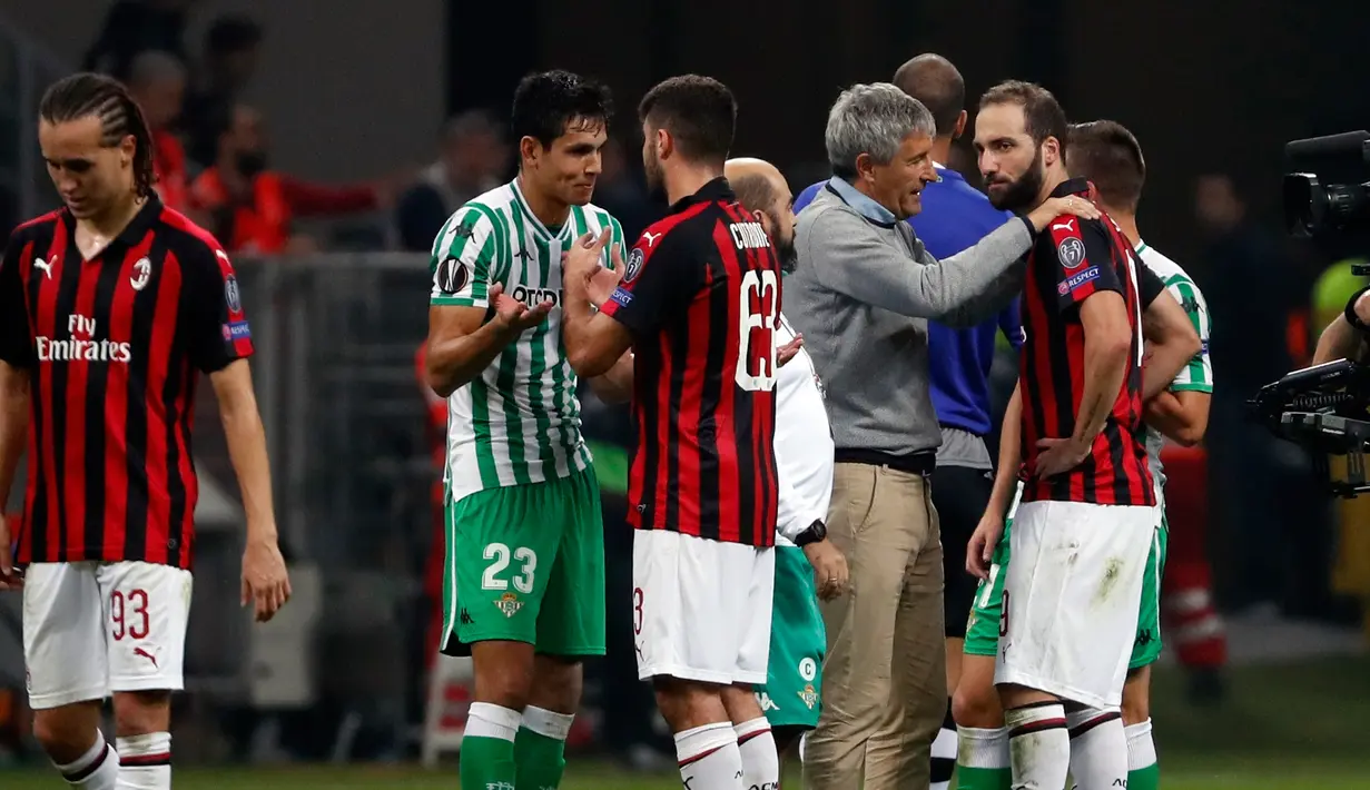 Pelatih Real Betis Enrique Stein Solar (ketiga kanan) berbicara dengan pemain AC Milan Gonzalo Higuain di akhir pertandingan Grup F Liga Europa di Stadion San Siro, Milan, Italia, Kamis (25/10). Real Betis menekuk AC Milan. (AP Photo/Antonio Calanni)