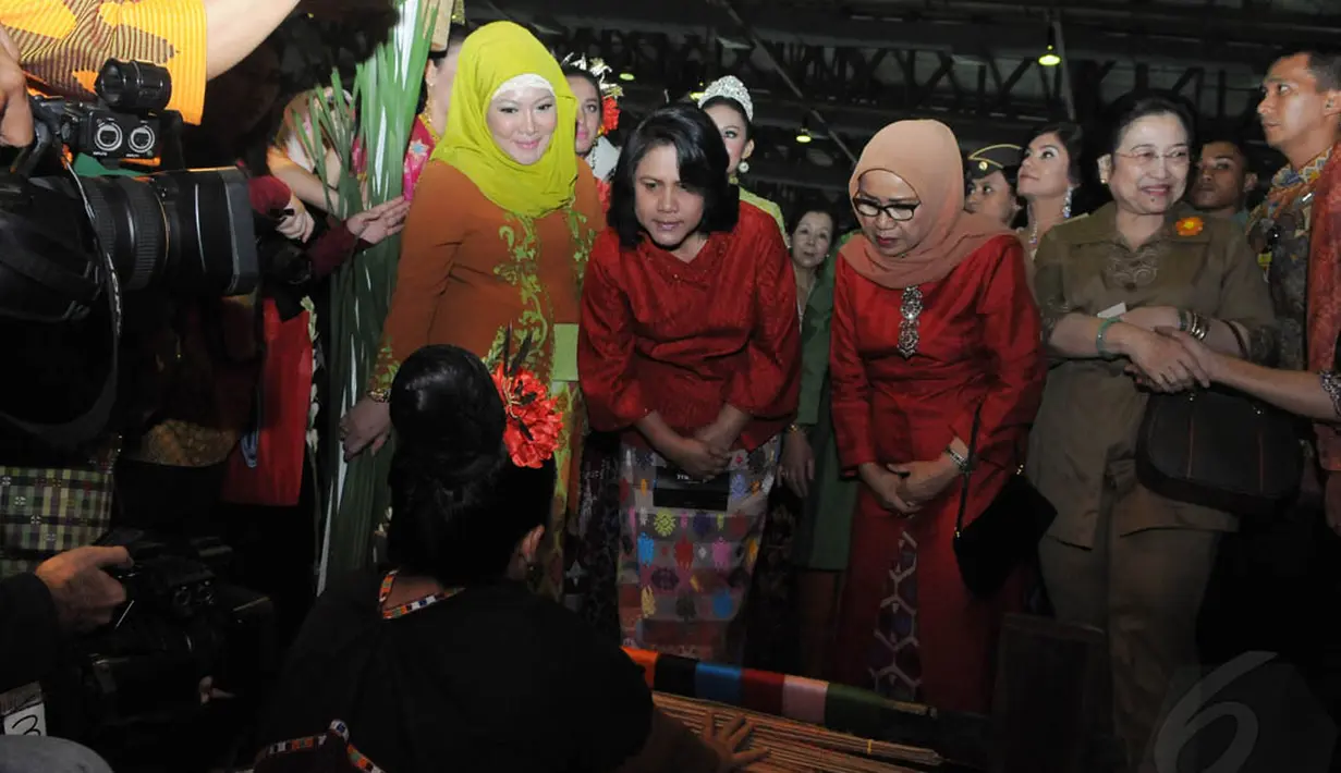 Saat tiba di salah satu gerai pameran, Iriana Joko Widodo berkesempatan melihat langsung teknik menenun tradisional khas NTB, Jakarta, Rabu (19/11/2014). (Liputan6.com/Herman Zakharia)