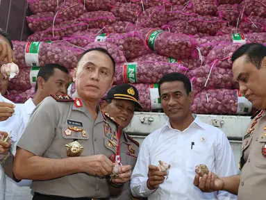 Menteri Pertanian Amran Sulaiman memperlihatkan bawang putih yang diimpor dari Tiongkok saat operasi pasar di Pasar Induk Kramat Jati, Rabu (17/5). Sebanyak 9.000 ton bawang putih dijual dengan harga Rp 25 ribu per kg. (Liputan6.com/Immanuel Antonius)