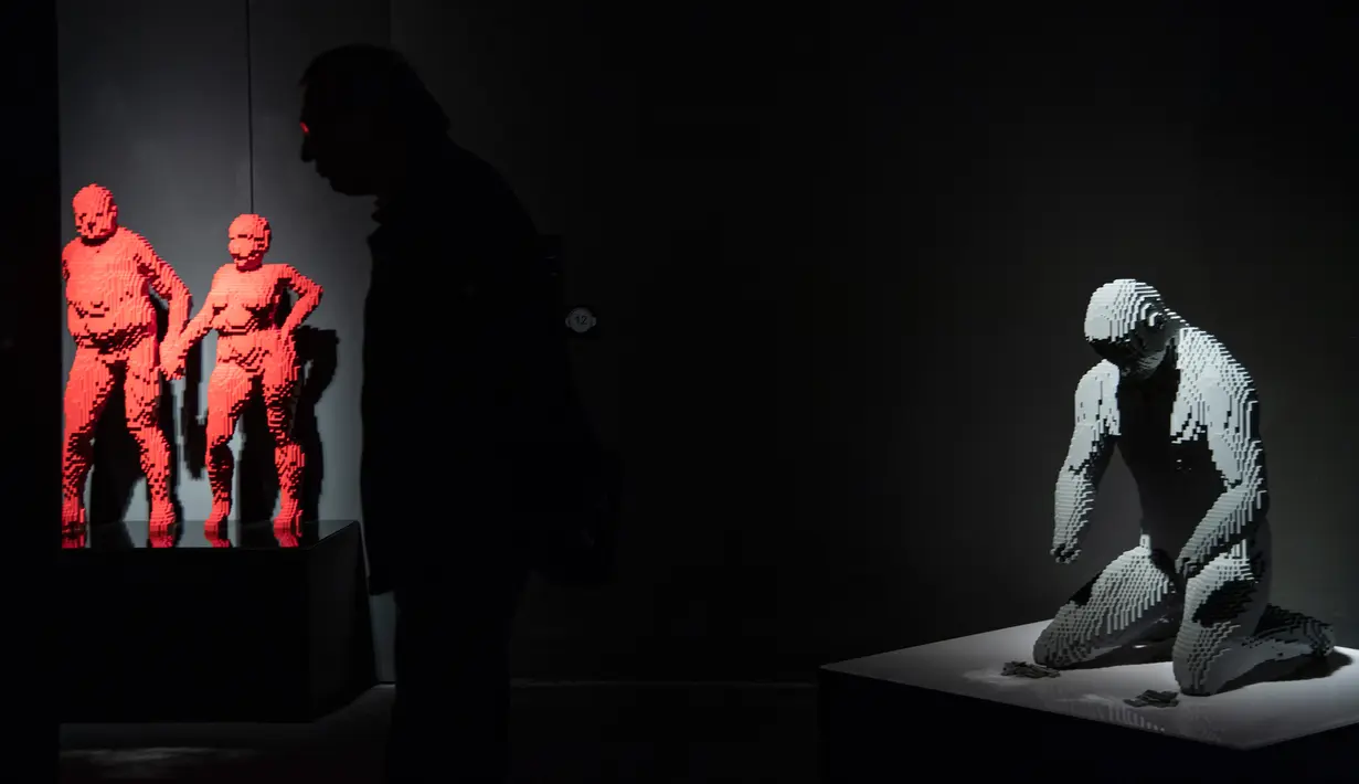 Pengunjung berjalan melewati patung "Mona Lisa" yang terbuat dari susunan balok lego pada pameran Art of the Brick di Turin, Italia, Kamis (15/11). Pameran tersebut menampilkan berbagai patung lego karya seniman AS, Nathan Sawaya. (MARCO BERTORELLO/AFP)