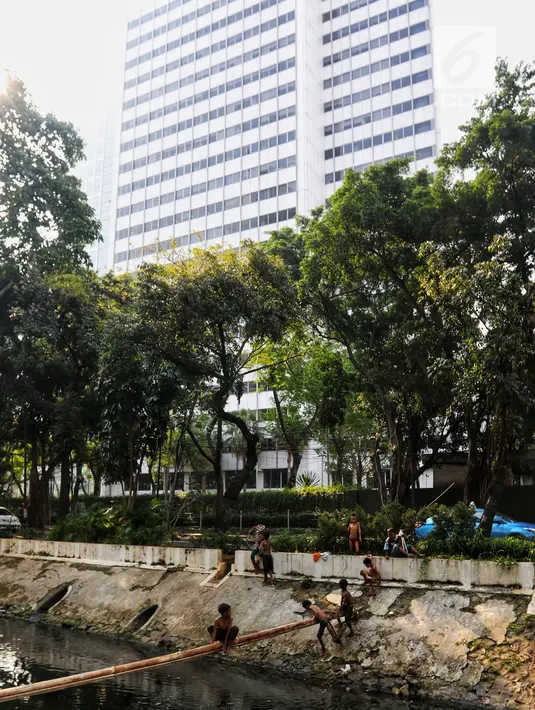 Anak-anak bermain di Kali Gresik di Jalan Muhammad Yamin, Menteng, Jakarta, Rabu (3/7/2019). Minimnya fasilitas bermain gratis, membuat anak-anak tersebut bermain ditempat yang tidak selayaknya. (Liputan6.com/Johan Tallo)