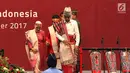 Presiden Joko Widodo usai membuka pameran Kriyanusa Dewan Kerajinan Nasional 2017, Jakarta, Rabu (27/9). Jokowi yang datang bersama Iriana Jokowi kompak mengenakan pakaian adat Batak lengkap dengan tutup kepalanya. (Liputan6.com/Angga Yuniar)