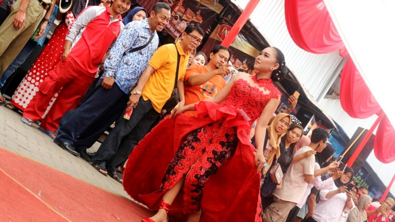 Pedagang pasar memperagakan busana pesta batik nan seksi dalam Peragaan busana batik bertajuk ‘Lenggak Lenggok Neng Pasar Segamas’, Purbalingga. (Liputan6.com/Dinkominfo PBG/Muhamad Ridlo)