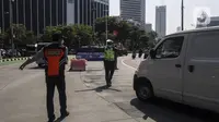 Polisi dan petugas Dinas Perhubungan mengatur arus lalu lintas saat pemberlakuan sistem ganjil genap di kawasan Jalan Sudirman, Jakarta, Kamis (12/8/2021). Kebijakan ini menggantikan penyekatan PPKM di delapan ruas jalan Ibu Kota. (Liputan6.com/Johan Tallo)
