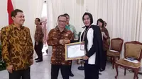 Kepala Biro Hubungan Masyarakat Akifah Elansary menerima piagam penghargaan di Istana Wakil Presiden yang diserahkan oleh Ketua KIP Gede Narayana.