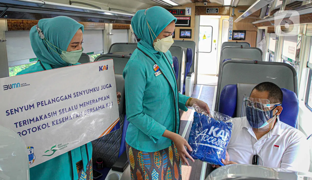 Petugas memberikan bingkisan kepada penumpang KA Taksaka di Stasiun Gambir, Jakarta, Sabtu (4/8/2021). Dalam rangka memperingati hari pelanggan nasional, PT KAI Daop 1 Jakarta membagikan ratusan bingkisan kepada penumpang kereta api. (Liputan6.com/Faizal Fanani)