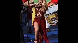 Tampil dengan gaun merah dan bawahan yang berkibar-kibar, penyanyi berusia 37 tahun itu memperlihatkan pesonanya di Stadion Macarana, Brasil, Senin (14/7/14). (AFP PHOTO/ADRIAN DENNIS)