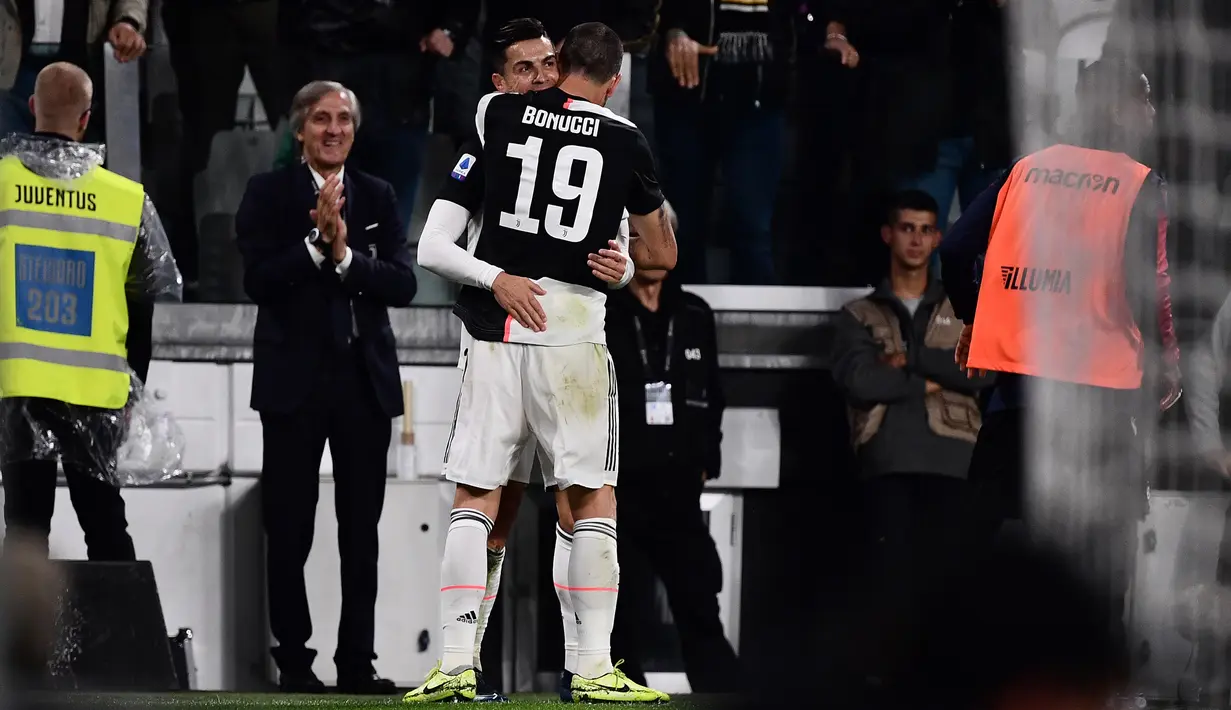 Penyerang Juventus, Cristiano Ronaldo memeluk rekannya Leonardo Bonucci setelah mencetak gol ke gawang Bologna pada pertandingan lanjutan Liga Serie A Italia di stadion Allianz, Turin (19/10/2019). Juventus menang tipis atas Bologna 2-1. (AFP Photo/Marco Bertorello)