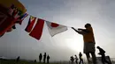 Seorang peserta mengikatkan bendera dari berbagai negara di balon udaranya sebelum mengikuti Festival QuickChek New Jersey di Kota Readington, New Jersey (28/7). (AP Photo/Julio Cortez)