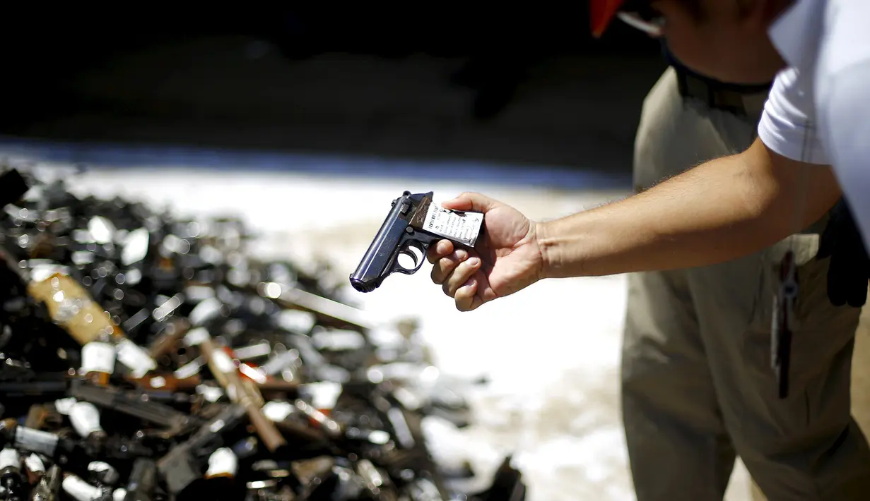 Petugas kepolisian tampak melihat kondisi senjata yang nantinya akan dimusnahkan di di Santiago, Chile, Senin (18/1). Senjata - senjata ini nantinya kan dimusnahkan dengan dilelehkan atau dibakar.  (REUTERS / Ivan Alvarado)