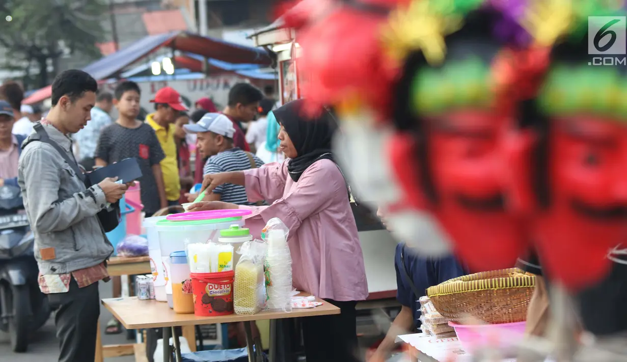 Pedagang melayani pembeli untuk berbuka puasa di sekitar Jalan Panjang Kelapa Dua, Jakarta, Selasa (7/5/2019). Beragam menu jajanan dijajakan pedagang musiman selama Ramadan. (Liputan6.com/Helmi Fithriansyah)