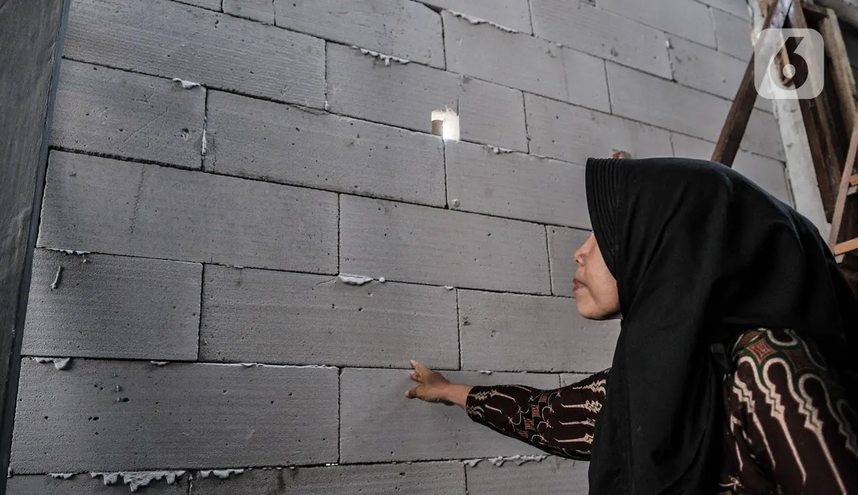 Wiwiek (56) menunjukkan tembok sekolah Pendidikan Perguruan Nasional (Pergunas) I yang menutup akses rumahnya di Jalan Cempaka Baru I, RT 015/003, Kemayoran, Jakarta, Senin (31/8/2020). Pembangunan itu menutup akses jalur keluar masuk dan harus melewati pintu samping. (merdeka.com/Iqbal S Nugroho)