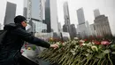 Orang-orang menaruh bunga mawar di atas nama korban pengeboman World Trade Center 1993 pada upacara peringatan “Tragedi 9/11” di New York, Rabu (26/2/2020). 27 tahun lalu teroris meledakkan bom di sebuah garasi parkir World Trade Center (WTC) yang menewaskan enam korban. (AP/John Minchillo)