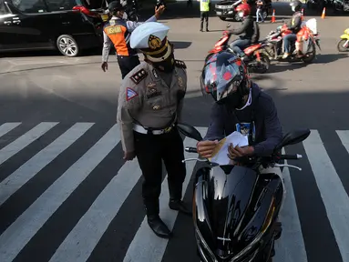Polisi memberhentikan pengendara sepeda motor saat penyekatan masa PPKM Darurat di Perempatan Fatmawati, Jakarta, Senin (12/7/2021). Penyekatan berlangsung hingga pukul 10.00 WIB. (merdeka.com/Arie Basuki)
