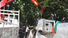 Petugas Dishub membongkar beton pembatas Jalan M. Yamin di depan bekas gedung Kedubes Inggris, Jakarta, Kamis (17/9/2015). Pembongkaran dilakukan karena beton tersebut akan dipergunakan di tempat lain. (Liputan6.com/Angga Yuniar)