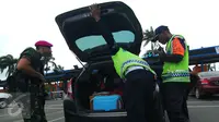 Petugas memeriksa bagasi mobil yang masuk di kawasan bandara Soetta Tangerang, Kamis, (14/01/16). Sejumlah anggota Kepolisian dan TNI AD dikerahkan untuk melakukan penjagaan di Bandara Soetta. (Liputan6.com/Faisal R Syam)