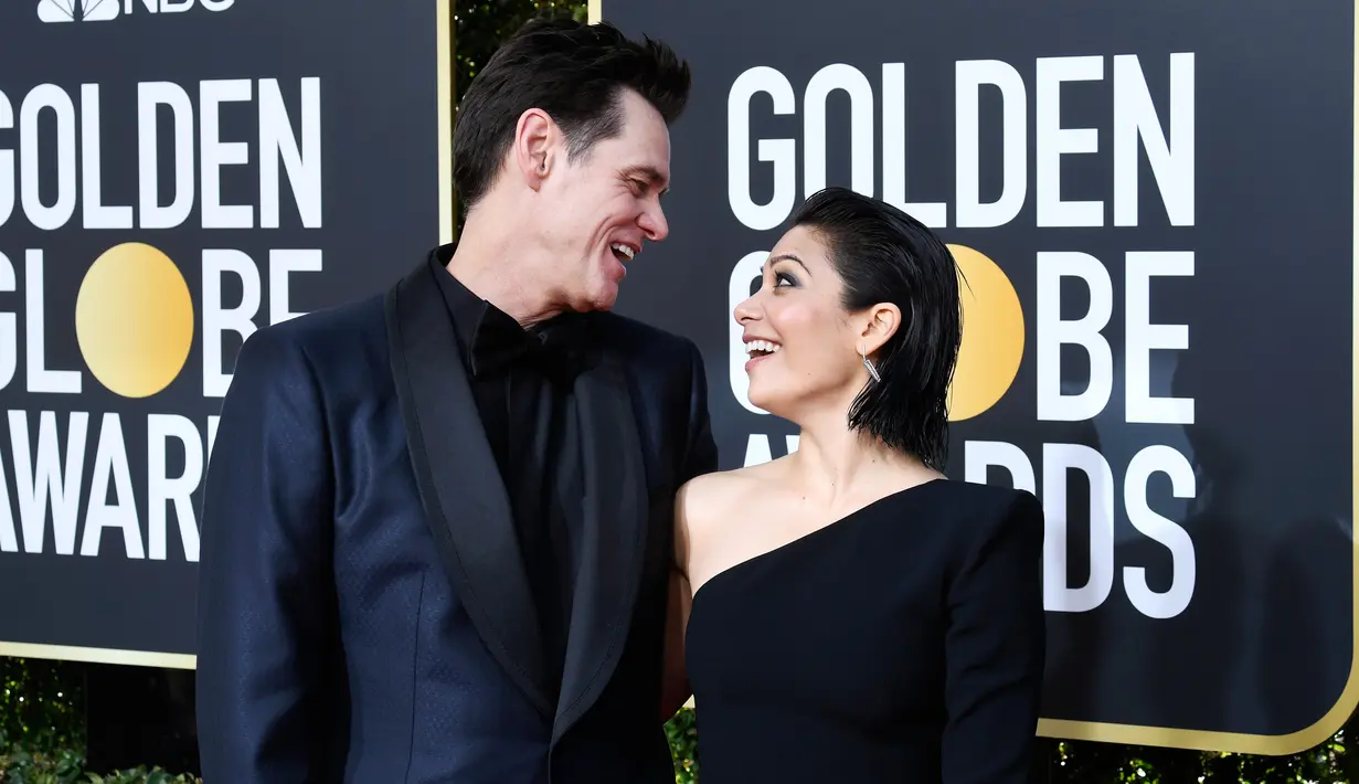 Komedian Jim Carrey dan Ginger Gonzaga bertatapan di karpet Golden Globe Awards ke-76 di Beverly Hills, California (6/1). Jim Carrey datang ke Golden Globes 2019 dengan menggandeng kekasih barunya, Ginger Gonzaga. (Frazer Harrison/Getty Images/AFP)