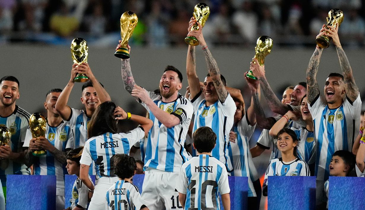 Lionel Messi dan rekan setimnya mengangkat trofi Piala Dunia saat merayakan kemenangan Argentina atas Panama pada pertandingan laga persahabatan di Stadion Monumental, Buenos Aires, Argentina, Kamis (23/3/2023). (AP Photo/Natacha Pisarenko)