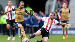 Pemain Arsenal, Theo Walcott (kiri), berebut bola dengan pemain Sunderland, Lee Cattermole, dalam laga Liga Inggris di Stadium of Light, Sunderland, Minggu (24/4/2016) malam WIB. (AFP/Graham Stuart)