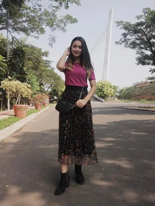 Tampil feminin dengan kombinasi t-shirt warna pink magenta, pleats skirt, dan sepatu boots. (Instagram/ersyaurel).