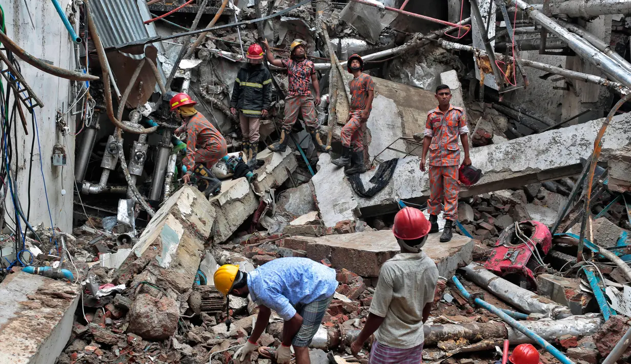 Petugas pemadam kebakaran penyelamat Bangladesh berdiri di puing-puing bekas ledakan di sebuah pabrik garmen di Dhaka, Bangladesh (4/7). Pabrik garmen di Bangladesh meledak hingga menewaskan 10 orang dan melukai puluhan lainnya. (AP Photo / AM Ahad)