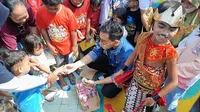 Gibran Rakabumning Raka sedang membagikan susu UHT kepada anak-anak di Taman Cerdas Panularan, Solo.(Liputan6.com/Fajar Abrori)