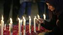 Seorang perempuan menyalakan lilin untuk para korban gempa bumi di Suriah dan Turki, di Islamabad, Pakistan, Senin, 6 Februari 2023. Gempa berkekuatan M7,8 telah mengguncang sebagian besar wilayah Turki dan Suriah. (AP Photo/Anjum Naveed)