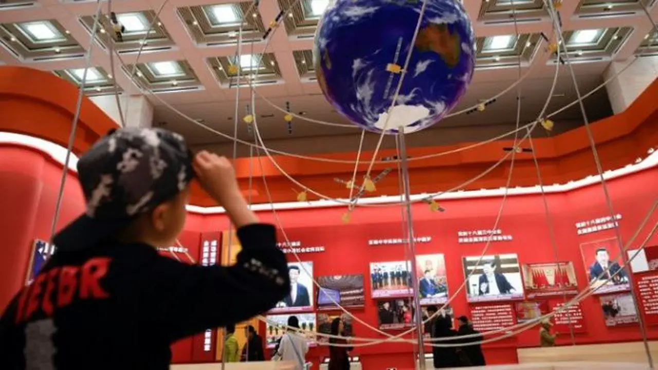 Model BeiDou Navigation Satellite System di National Museum of China di Beijing, yang tampak tengah diamati oleh seorang anak. (Photo credit: AFP Photo/WANG ZHAO)