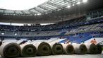 Sejumlah pekerja sedang memasang rumput hybrid baru di Stade de France, Saint-Denis, pada 24 Mei 2022 waktu setempat. Dalam waktu 48 jam, rumput baru yang ditanam di luar Barcelona, dipasang di Stade de France untuk pertandingan final Liga Champions antara Real Madrid dan Liverpool yang dijadwalkan berlangsung pada 28 Mei 2022. (AFP/Franck Fife)