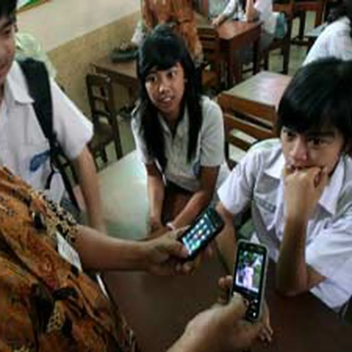 Seorang guru mengecek isi telepon genggam milik siswa untuk mencegah  beredarnya film porno di SMA Santo Yosef di Solo, Jateng. (Antara) - Photo  Liputan6.com