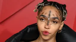 FKA Twigs berpose untuk fotografer setibanya di British Fashion Awards di London, Senin, 5 Desember 2022. Penyanyi sekaligus penulis lagu asal Inggris itu tampil mengenakan tampilan riasan unik di acara tersebut. (AFP/DANIEL LEAL)