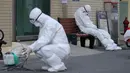 Petugas medis beristirahat saat menunggu pasien virus corona (COVID-19) di luar sebuah rumah sakit di Daegu, Korea Selatan, Minggu (23/2/2020). Korea Selatan mengonfirmasi 293 kasus baru virus corona pada 4 Maret 2020 sore. (YONHAP/AFP)