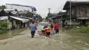 Penjaga pantai dan personel polisi mengevakuasi seorang penduduk dari daerah banjir di Kota Abuyog, Provinsi Leyte, Filipina, 11 April 2022. Banjir terjadi menyusul hujan lebat yang disebabkan oleh badai tropis Agaton. (Philippine Coast Guard (PCG)/AFP)