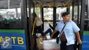 Kondektur bus Angkutan Perbatasan Terintegrasi Busway (APTB) saat menaikan penumpang di halte Transjakarta BNN, Cawang, Jakarta, Selasa (8/3/2016). Pemprov DKI kembali perbolehkan APTB kembali beroperasi dengan sejumlah syarat. (Liputan6.com/Yoppy Renato)