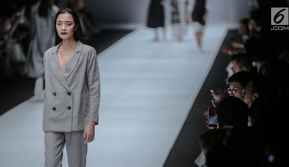 Model memperagakan busana persembahan "COTTONINK" pada Jakarta Fashion Week 2019 di Senayan City, Rabu (24/10/2018). Pada peragaan busana tersebut "COTTONINK" mempersembahkan sejumlah rancangan dari beberapa artis. (Liputan6.com/Faizal Fanani)