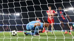 Kiper Girona, Paulo Gazzaniga gagal menangkap bola dari umpan silang pemain PSG, Nuno Mendes pada laga Liga Champions 2024/2025 yang berlangsung di Parc des Princes, Paris, Prancis, Kamis (19/09/2024). (AFP/Franck Fife)