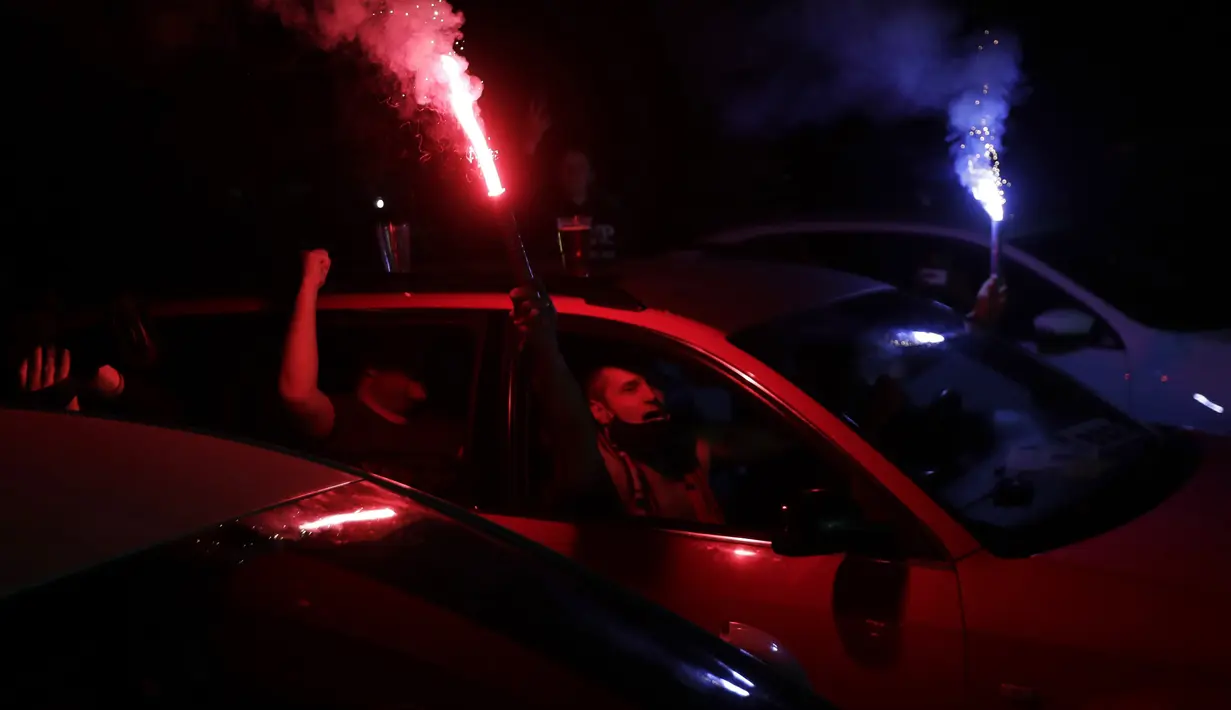 Suporter menyalakan flare saat menyaksikan pertandingan Viktoria Plzen dan Sparta Praha di sebuah bioskop drive-in di Pilsen, Republik Ceko, Rabu (27/5/2020). Di tengah pandemi COVID-19, suporter Ceko dapat menyaksikan pertandingan bola lewat layar di bioskop drive-in. (AP Photo/Petr David Josek)