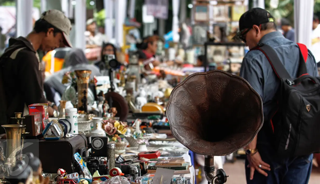Penggemar barang antik menyaksikan pagelaran 'Jakarta Vintage Weekend Market', di Tugu Proklamasi, Jakarta, Minggu (20/12/2015). Kegiatan ini dalam rangka mengumpulkan sumbangan untuk para veteran yang hidup miskin. (Liputan6.com/Faizal Fanani)