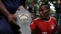 Seorang pekerja memegang batu nisan saat prosesi pemakaman terpidana mati Zainal Abidin di TPU di Cilacap, Jawa Tengah, Rabu (29/4/2015). Zainal satu-satunya terpidana mati asal Indonesia yang dieksekusi pada dini hari ini. (REUTERS/Beawiharta)