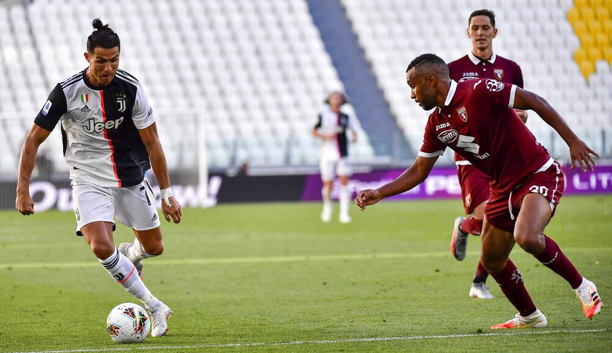 Striker Juventus, Cristiano Ronaldo, berusaha melewati pemain Torino pada laga Serie A di Stadion Allianz, Turin, Sabtu (4/6/2020). Juventus menang 4-1 atas Torino. (AP/Marco Alpozzi)