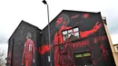 Mural seniman Inggris, John Culshaw yang menggambarkan pesepak bola Mesir Mohamed Salah dilukis di fasad bangunan dekat Stadion Anfield, di Liverpool, Rabu (30/3/2022). Mohamed Salah sudah berada di urutan kesembilan dalam daftar pencetak gol sepanjang masa Liverpool. (Paul ELLIS / AFP)