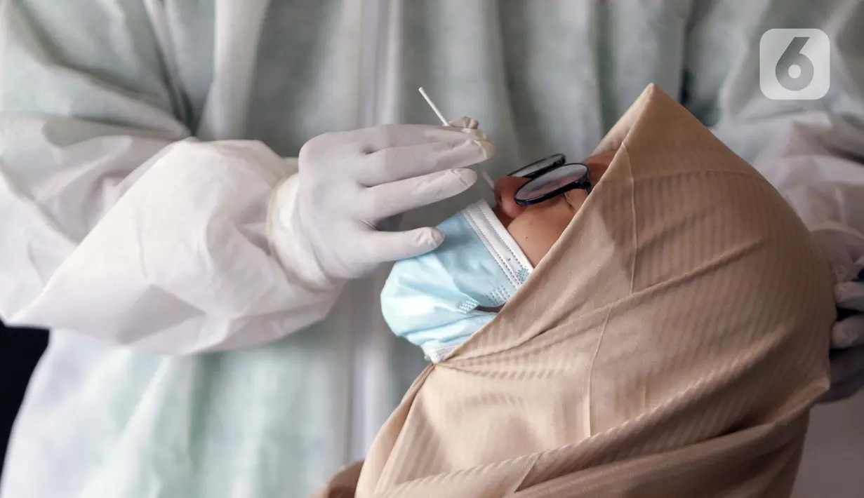 Petugas medis mengambil sample rapid test antigen di Terminal Bus Antar Kota Antar Provinsi Kampung Rambutan, Jakarta, Kamis (20/5/2021). Penumpang bus yang tiba maupun berangkat diwajibkan menjalani pengecekan bebas COVID-19 melalui rapid test antigen atau GeNose. (Liputan6.com/Helmi Fithriansyah)