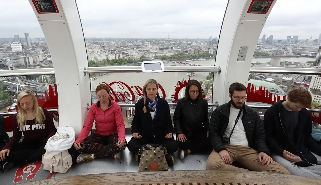Suasana saat peserta melakukan meditasi di salah satu dari tiga kapsul London Eye di London, Inggris (15/5). Kegiatan meditasi ini terlihat unik, karena dilakukan diatas ketinggian didalam London Eye. (AP Photo / Alastair Grant)